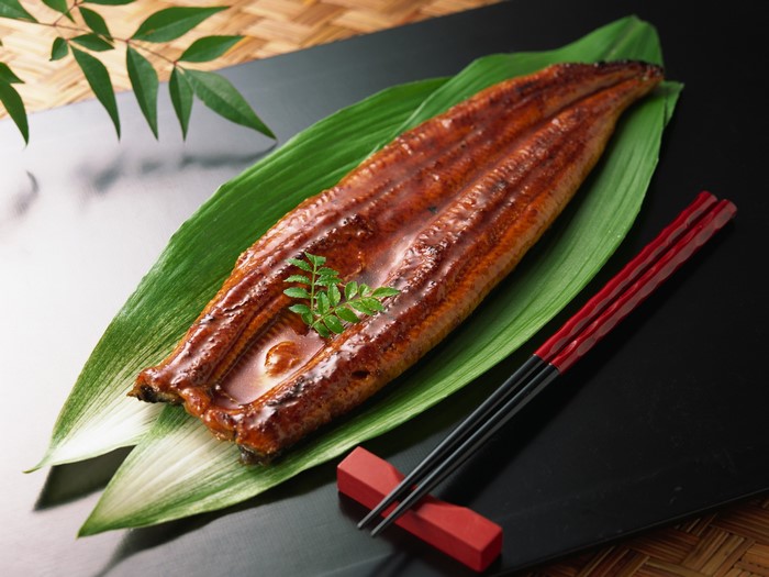 Grilled eel on a banana leaf with chopsticks