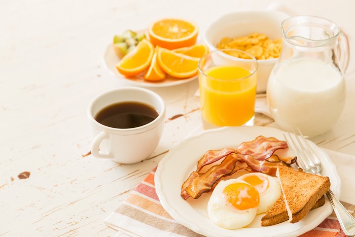 Breakfast with Coffee, Juice, Milk, Bacon, Eggs, and Toast