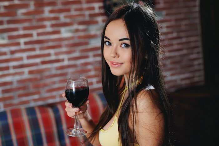 Brunette girl Li Moon holding a glass of wine