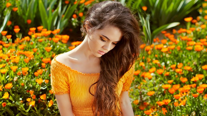 Brown haired woman in yellow top with orange flowers