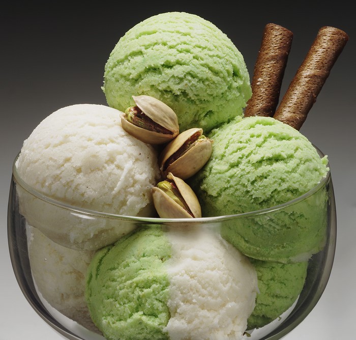 Ice cream sundae with pistachios and wafer rolls