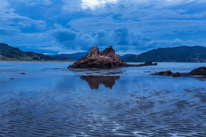 Rock formation in Waikawau Bay, New Zealand at dusk