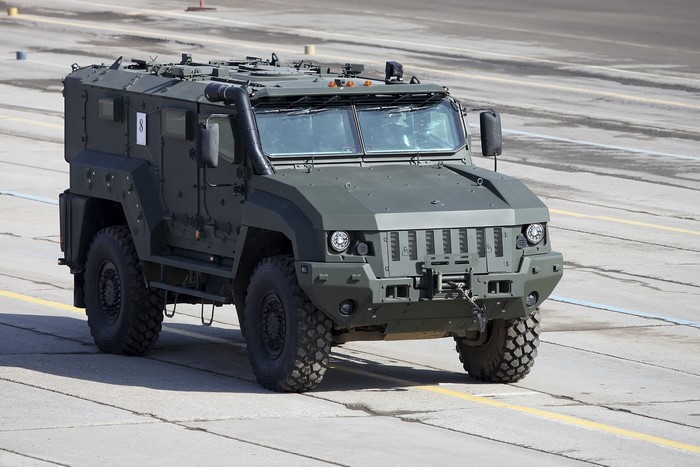 Green armored military vehicle with large tires