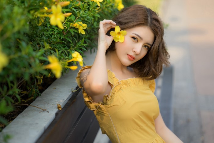 4K Portrait of Cute Woman with Yellow Flower