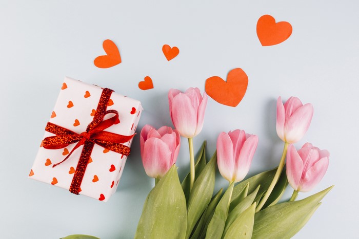 Gift box with pink tulips and red hearts