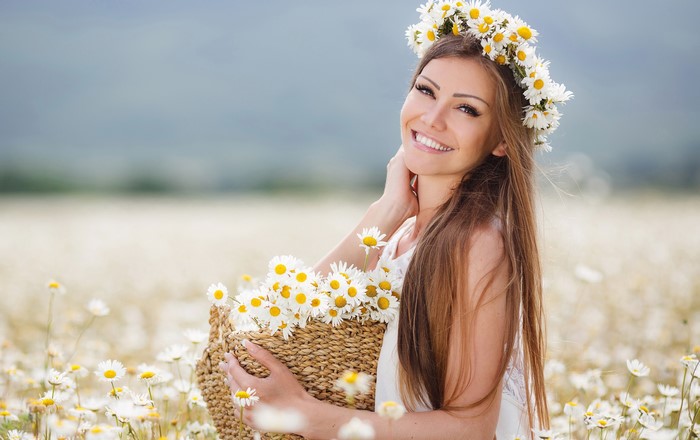 Woman with a flower crown and basket of camomiles