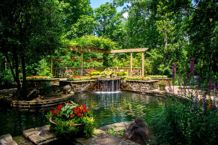 Gibbs Gardens pond with waterfall and flowers