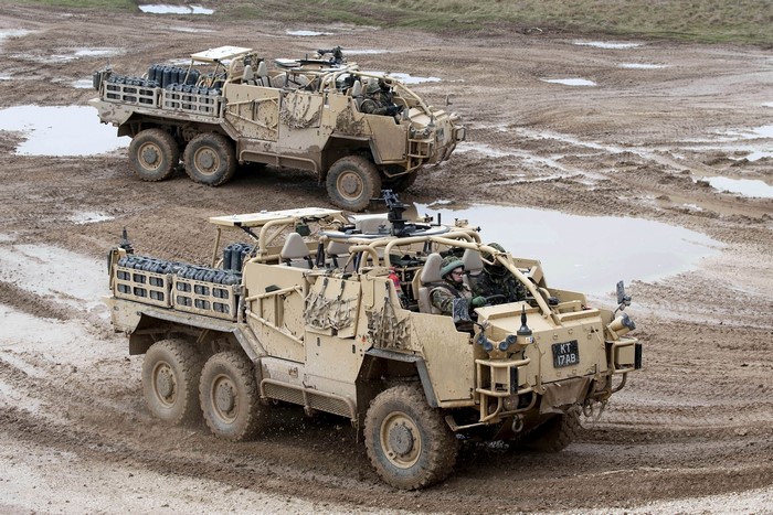 Two Coyote TSV military vehicles in muddy terrain