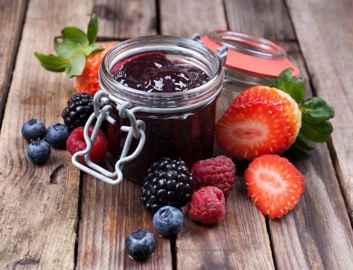Jar of Berry Jam with Fresh Berries on Wood
