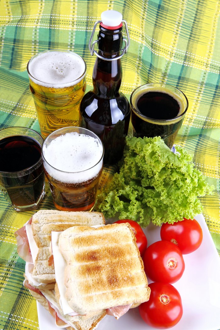 Beer, Sandwiches, Tomatoes, and Lettuce on a Plaid Cloth