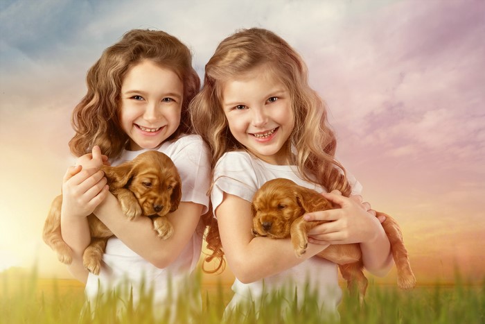 Two little girls holding puppies