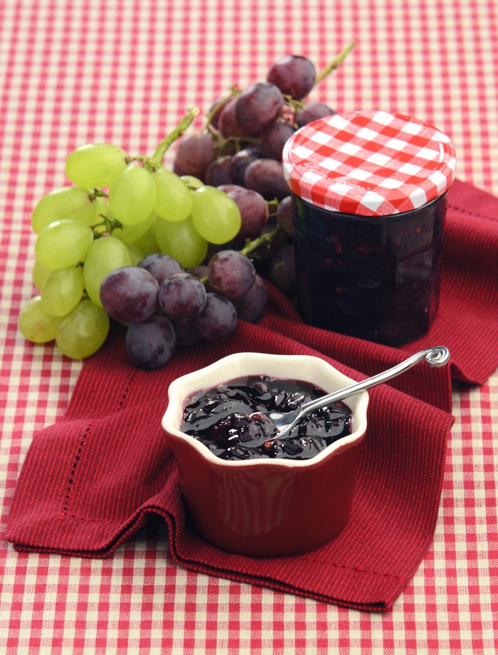 Grape jam in a jar and bowl with grapes