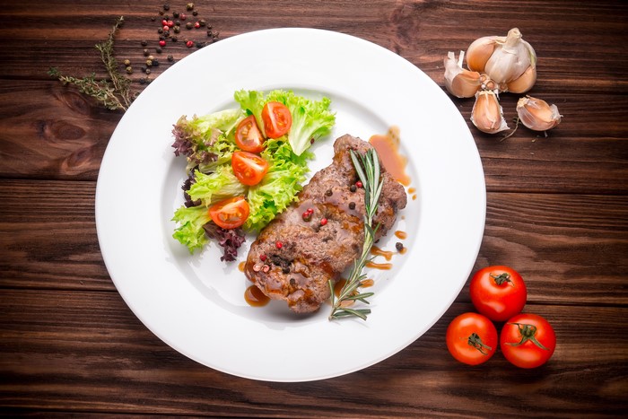Steak with salad and tomatoes on a plate