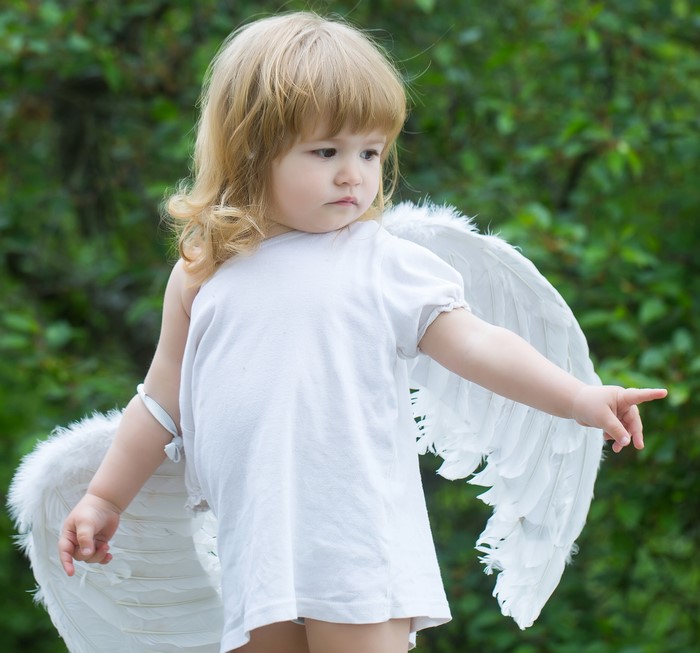 Little girl with blonde hair and angel wings