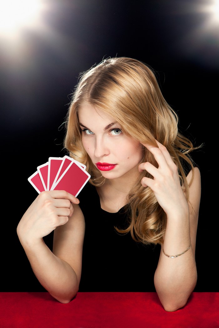 Blonde woman holding red playing cards