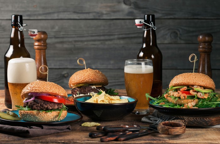 Two hamburgers with beer and chips