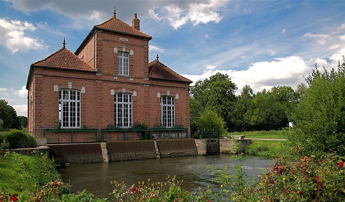 Brick building by a river in Long Picardy, France
