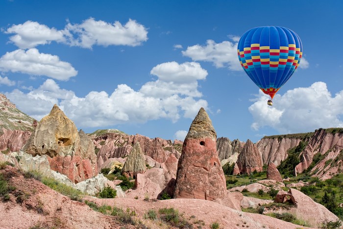 Hot air balloon over Cappadocia rock formations in Turkey
