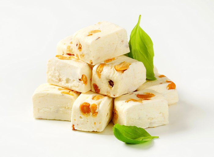 Pieces of nougat with nuts and basil leaves
