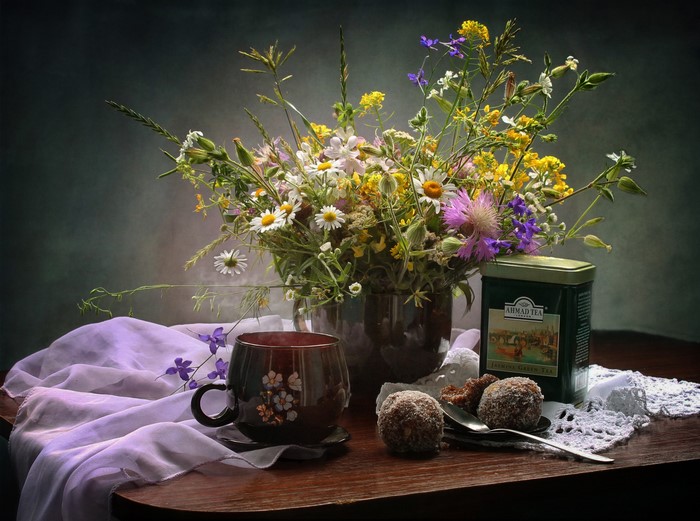 Still life with wildflowers, tea, and sweets