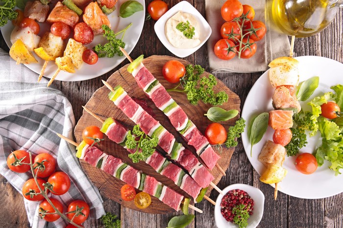 Raw meat and fish skewers with tomatoes and vegetables
