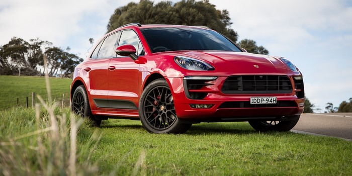 Red Porsche Macan GTS parked on grass