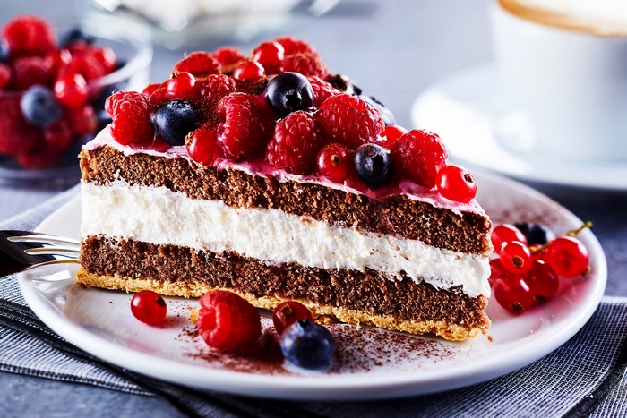 Slice of chocolate cake with berries on a plate