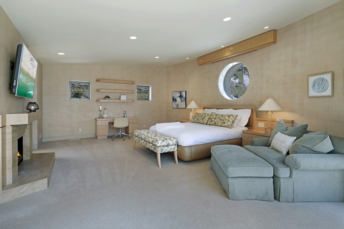 Bedroom with fireplace, desk, and bed
