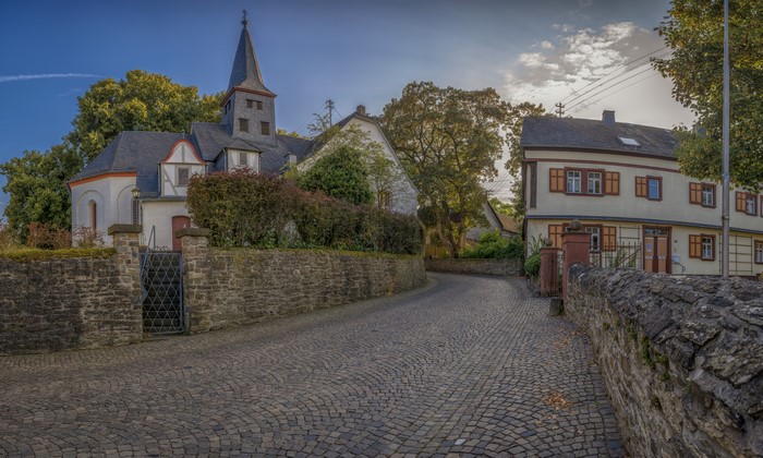 Church and houses on a cobblestone street in Miehlen, Germany