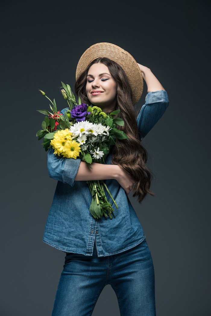 Woman in straw hat holding a bouquet of flowers