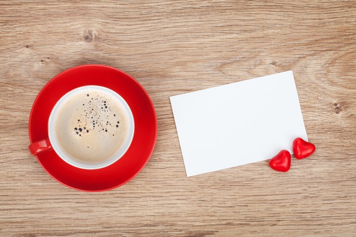 Coffee cup with two heart candies and a blank card
