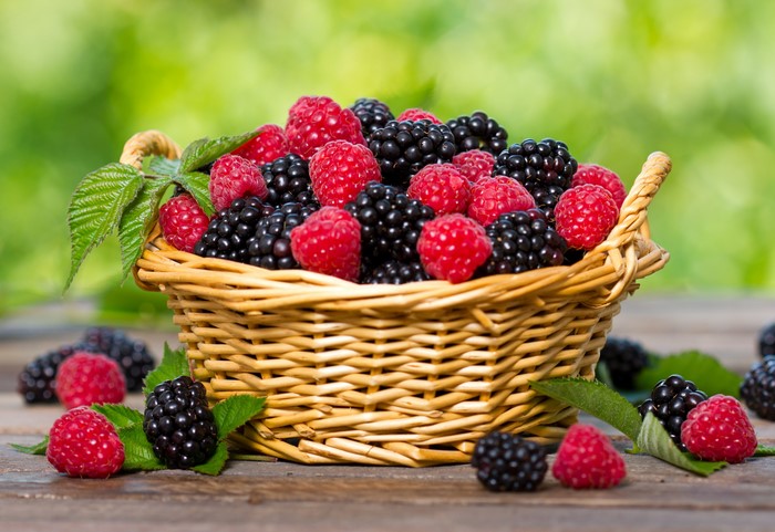 4K Wicker basket full of raspberries and blackberries