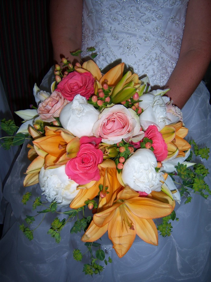 Bride holding a bouquet of roses and lilies