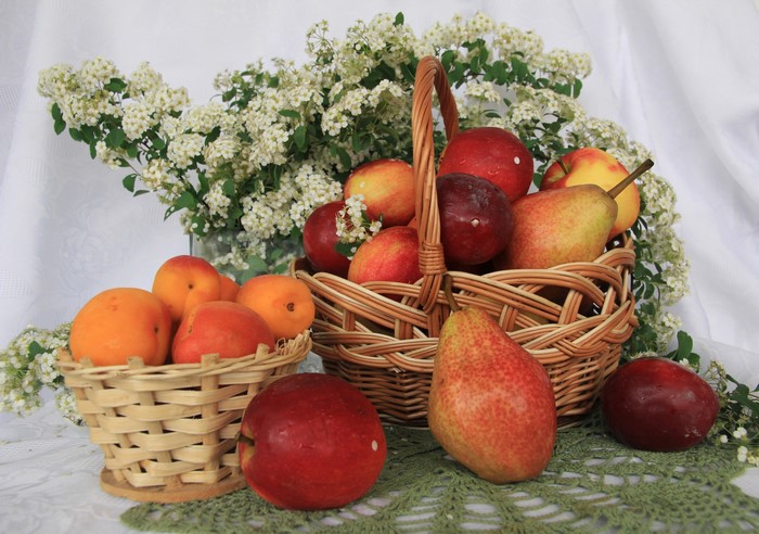 Still life of fruits in baskets with flowers