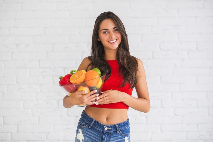 Woman holding a bowl of fruit