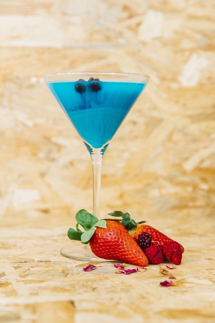 Blue cocktail with berries and strawberries