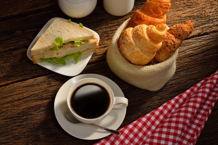 Coffee, Croissant, and Sandwich on Wood Planks