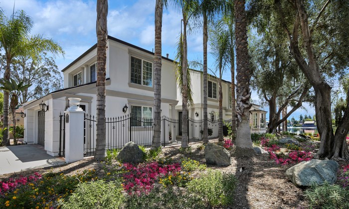 White house with fence and trees near Bayshore Lake Forest, California