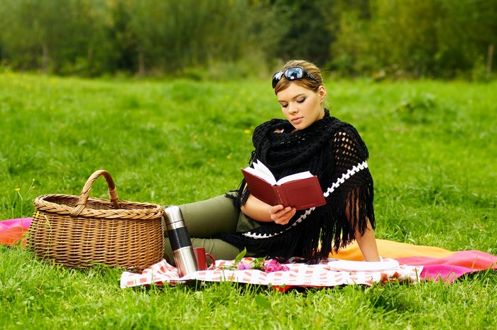 Woman reading a book at a picnic