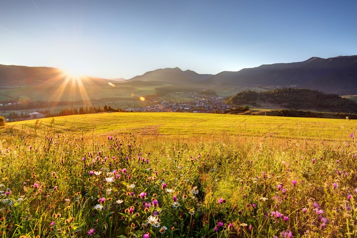Sunrise over a valley with a village and fields