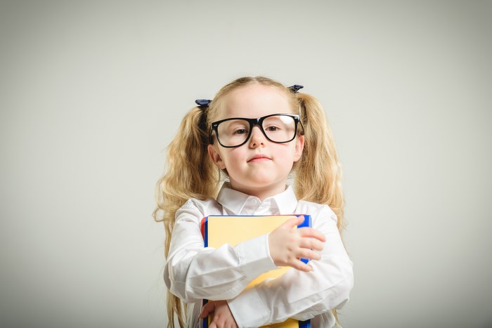 Little girl with glasses holding books