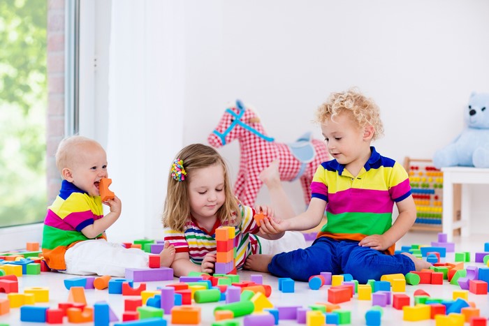 Three Children Playing with Colorful Blocks
