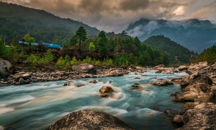 River flowing through rocky terrain with mountains and forest