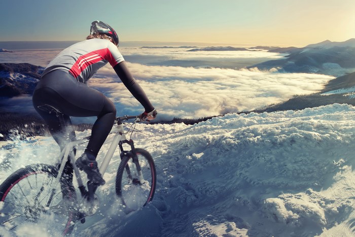 Mountain biker riding through snow