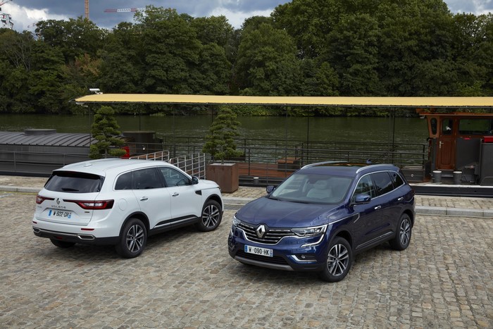 Two Renault Koleos SUVs parked by a river