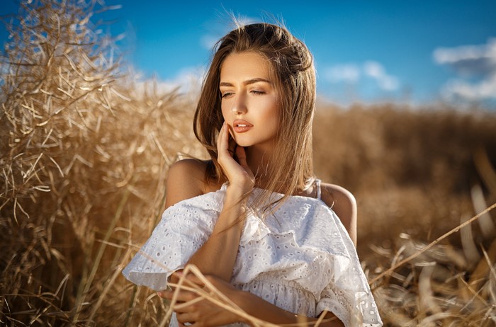 Beautiful woman with dark blonde hair in a field