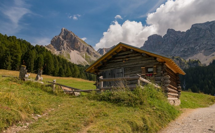 Wooden cabin in the Italian Alps with mountains and forest