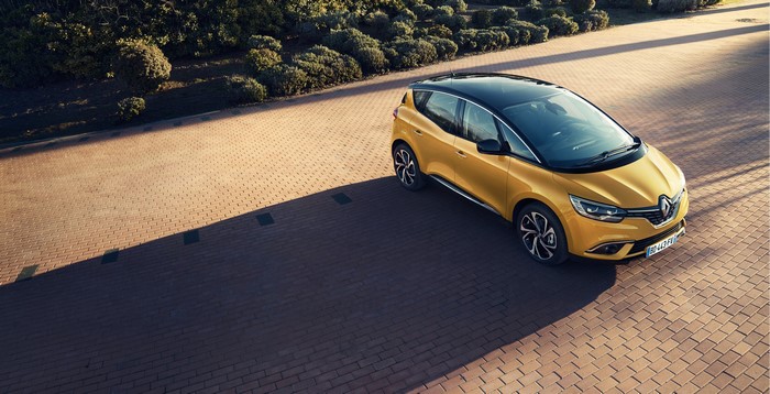 Yellow Renault Scenic parked on brick pavement
