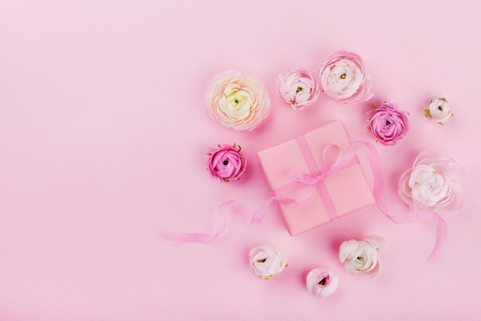 Pink gift box with ranunculus flowers and ribbon