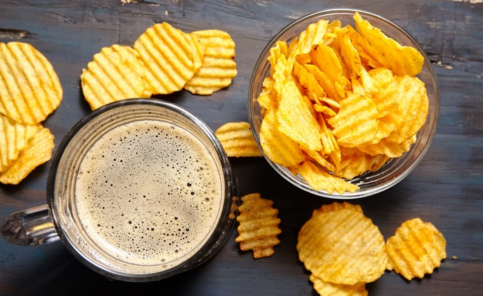 Beer and Ruffled Potato Chips on Wood
